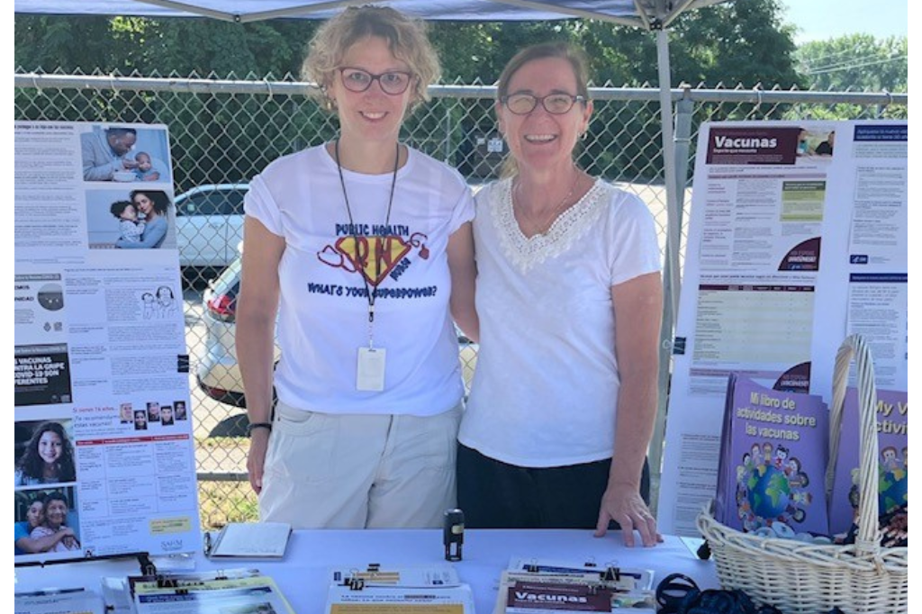 Two MA Vaccine Confidence project staff at the project booth at a health fair